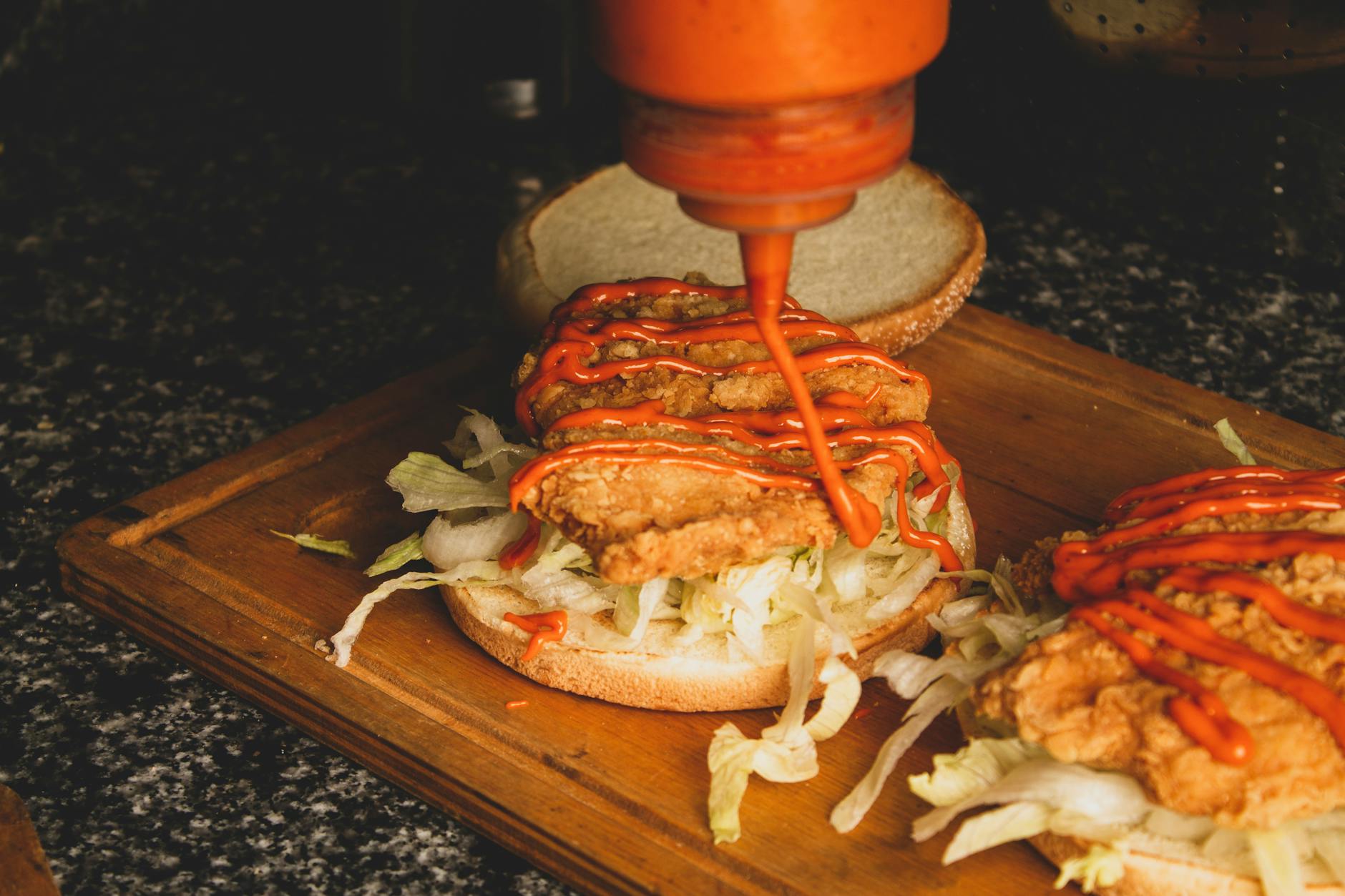 pouring sauce on burger meat