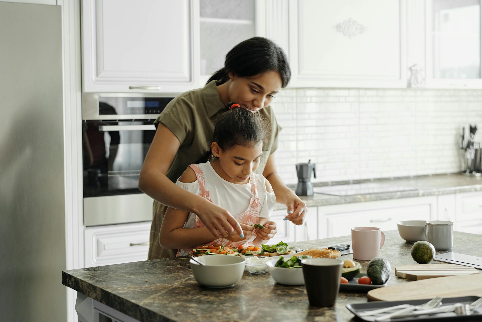 Natural immune boosters for kids are found in the kitchen- mom and daughter incorporating immune boosting foods
