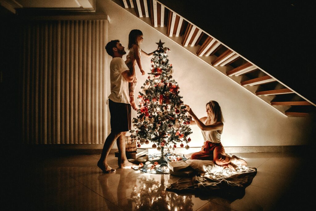 Toddler decorating a Christmas tree or making a simple craft, showing how everyday activities can become Christmas traditions for toddlers.